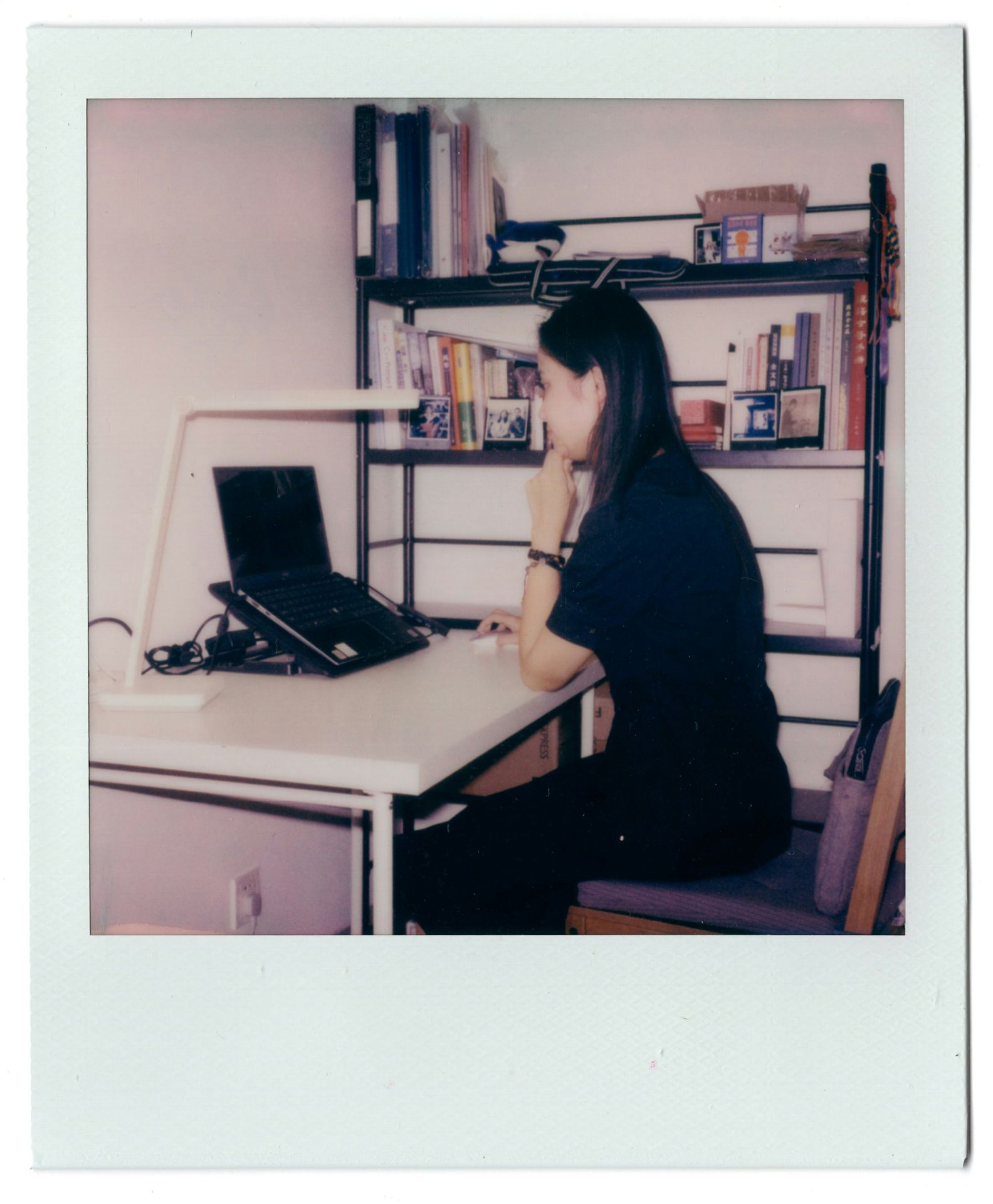 A woman sitting at a desk using a laptop computer